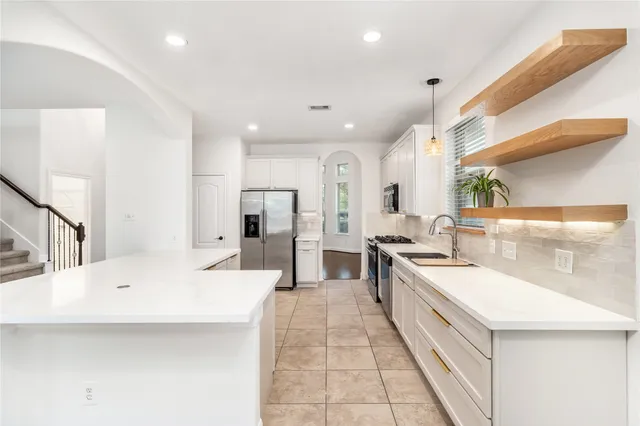 a large white kitchen with a large window