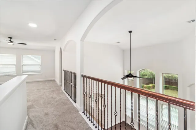an empty room with wooden floor fireplace and windows
