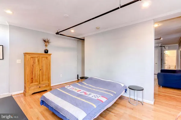 a bedroom with a bed and wooden floor