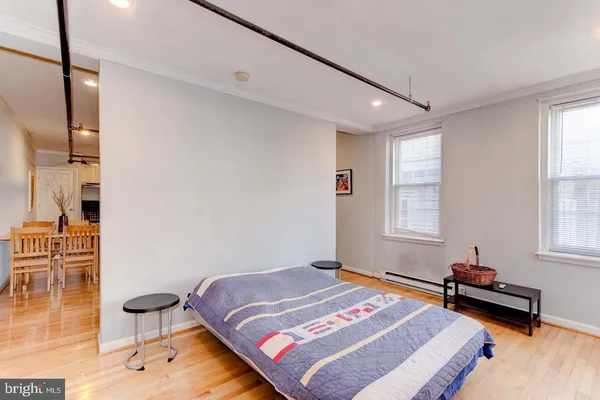 a bedroom with a bed and wooden floor
