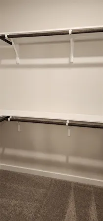 a view of walk in closet with empty racks