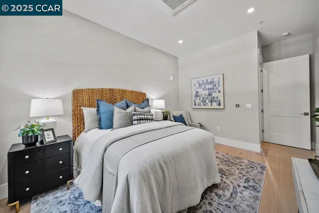 a bedroom with a bed and a lamp on dresser