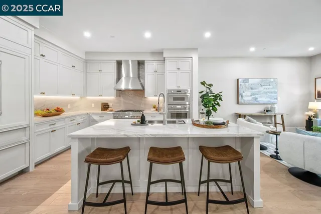 a kitchen with white cabinets and chairs