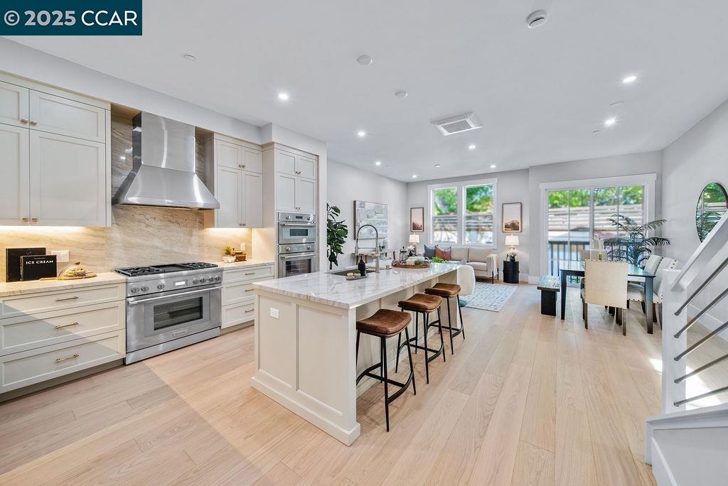 600 Hartz Avenue, Unit 103 Danville, CA 94526 - Photo 10 of 34 a kitchen with stainless steel appliances kitchen island granite countertop a stove a sink a refrigerator and white cabinets