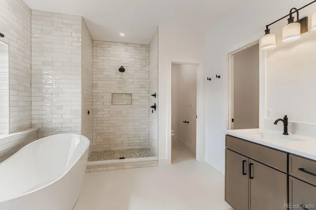a bathroom with a granite countertop bathtub shower sink vanity and mirror