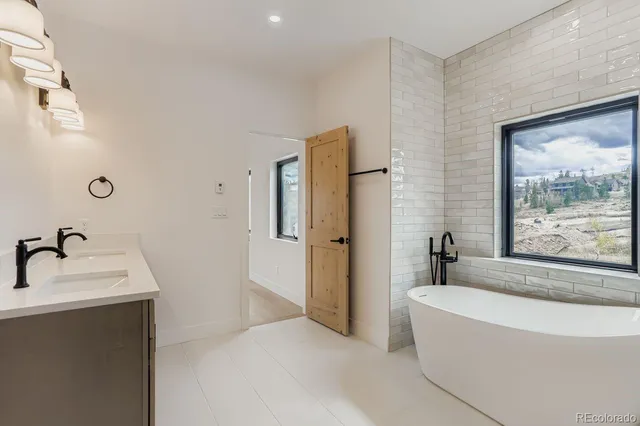 a bathroom with a tub sink and mirror