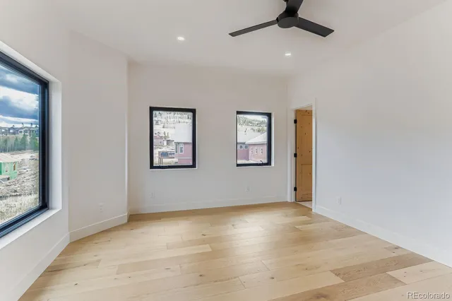an empty room with windows and fan