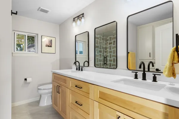 a bathroom with a granite countertop sink mirror and toilet