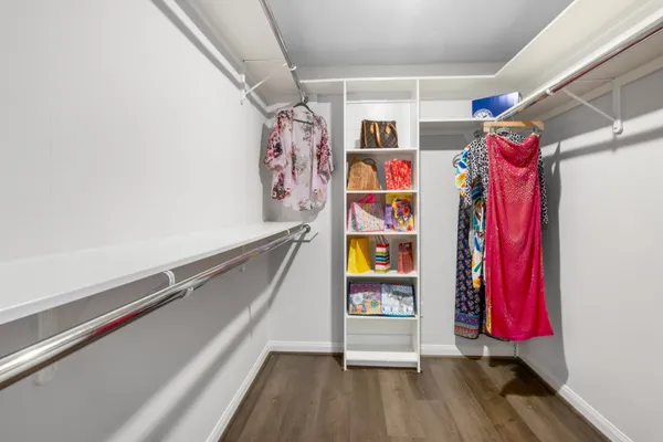 a view of walk in closet with clothes and shoes