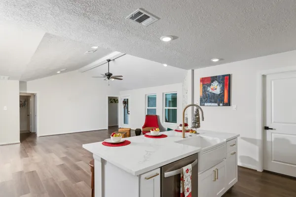 a room with kitchen island a sink and a refrigerator