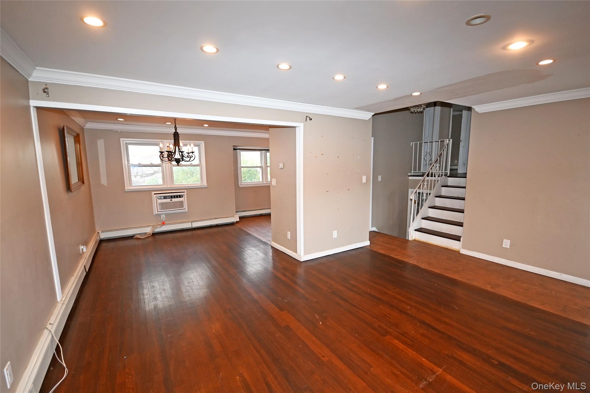 89 Osborne Road West Hempstead, NY 11552 - Photo 27 of 50 Unfurnished living room with ornamental molding, recessed lighting, stairway, wood-type flooring, and a wall unit AC
