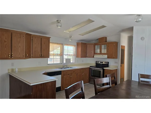 a kitchen with kitchen island a counter top space a sink stainless steel appliances and cabinets