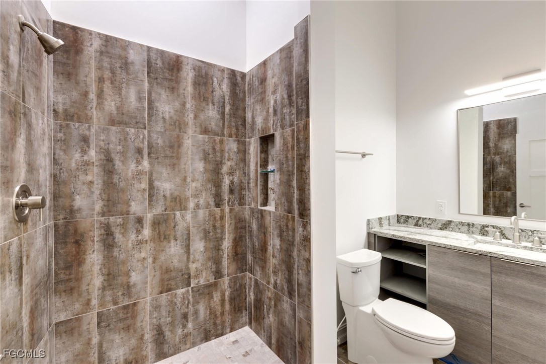 2278 First Street, Unit 204 Fort Myers, FL 33901 - Photo 11 of 24 a bathroom with a granite countertop toilet a sink and a shower