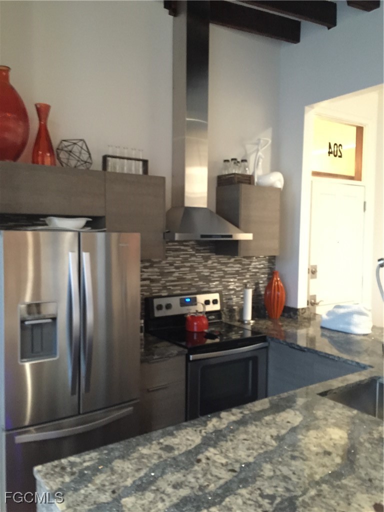 2278 First Street, Unit 204 Fort Myers, FL 33901 - Photo 17 of 24 a kitchen with stainless steel appliances granite countertop a refrigerator and a stove