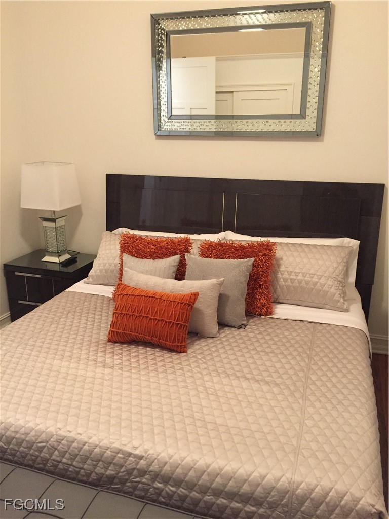 2278 First Street, Unit 204 Fort Myers, FL 33901 - Photo 20 of 24 a bedroom with a bed and a night stand