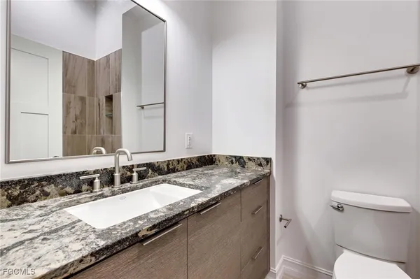 a bathroom with a granite countertop sink and a mirror