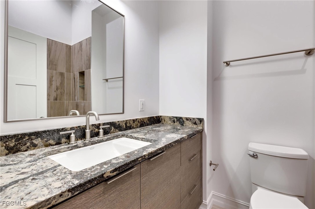 2278 First Street, Unit 204 Fort Myers, FL 33901 - Photo 3 of 24 a bathroom with a granite countertop sink and a mirror