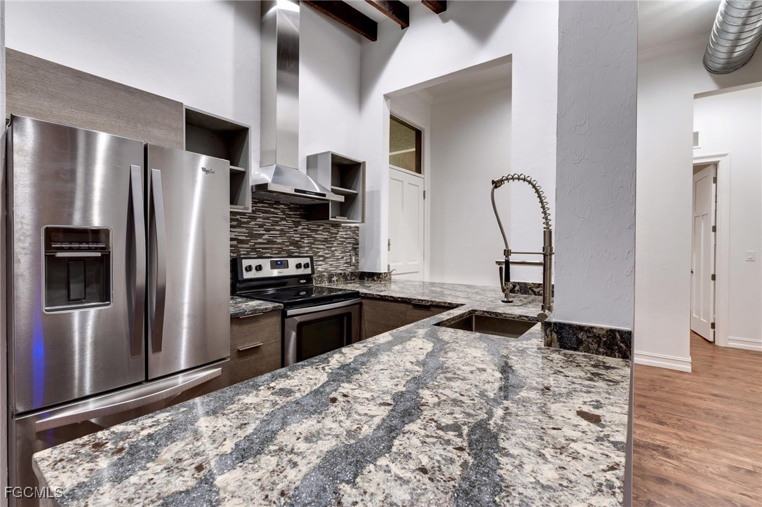 2278 First Street, Unit 204 Fort Myers, FL 33901 - Photo 4 of 24 a kitchen with stainless steel appliances granite countertop a refrigerator and a stove top oven