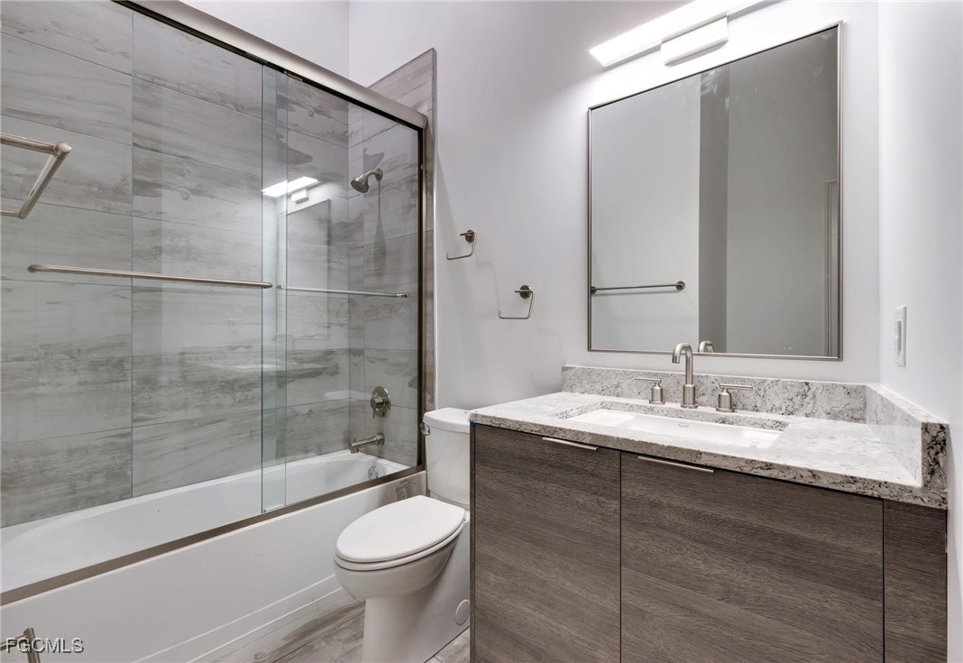 2278 First Street, Unit 204 Fort Myers, FL 33901 - Photo 10 of 24 a bathroom with a double vanity sink toilet and shower