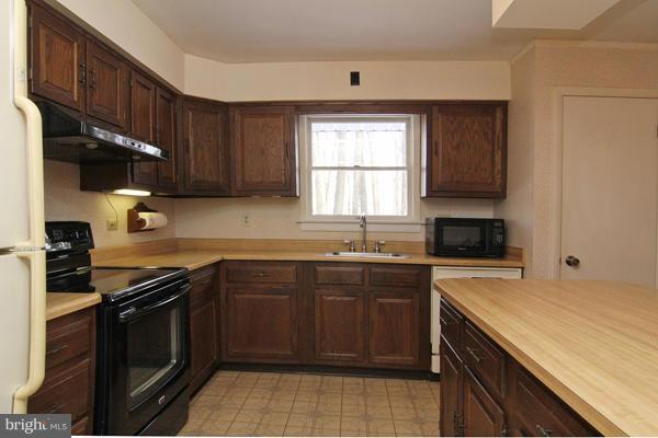 21601 Gunpowder Road Manchester, MD 21102 - Photo 14 of 30 a kitchen with a sink stove top oven and cabinets