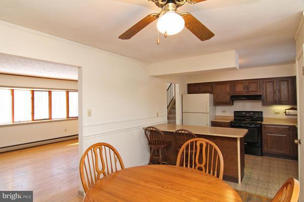 21601 Gunpowder Road Manchester, MD 21102 - Photo 15 of 30 a kitchen with stainless steel appliances granite countertop a stove a sink a refrigerator dining table and chairs with wooden floor