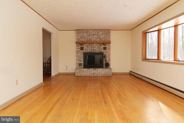 21601 Gunpowder Road Manchester, MD 21102 - Photo 3 of 30 a view of an empty room with a fireplace and a window