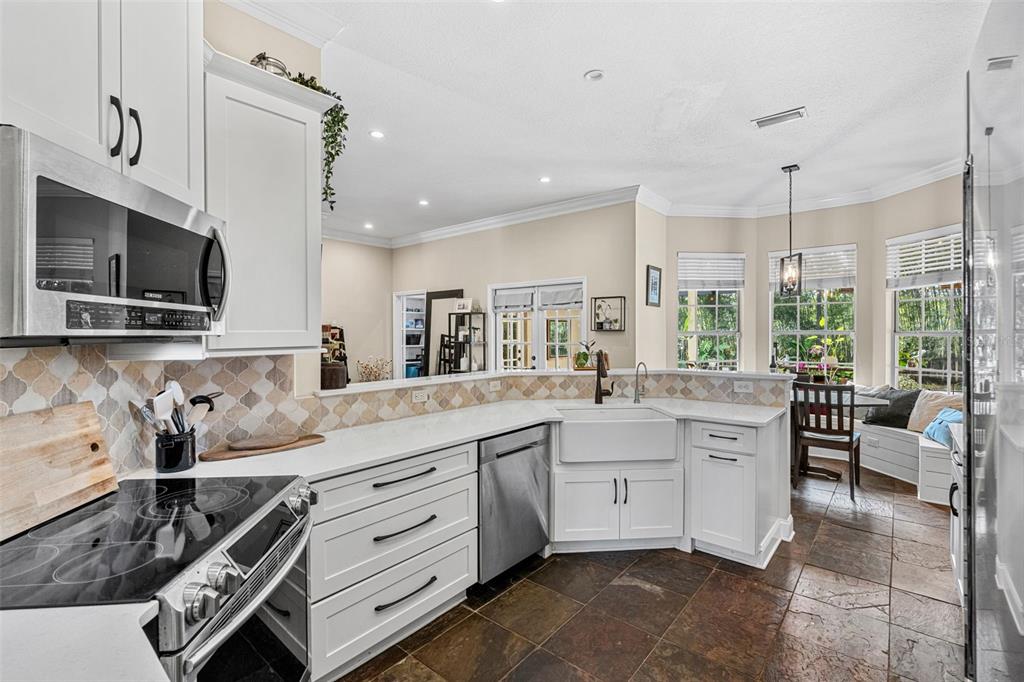 1674 Victoria Way Winter Garden, FL 34787 - Photo 12 of 42 a kitchen with stainless steel appliances kitchen island granite countertop a sink and cabinets