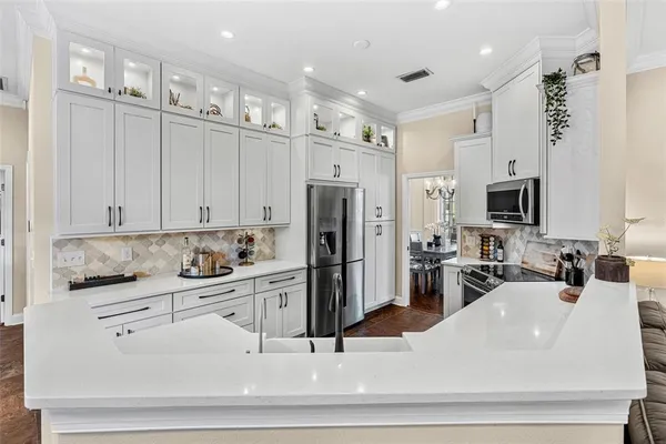 a kitchen with white cabinets and stainless steel appliances
