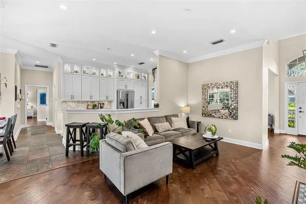 a living room with furniture and a dining table with wooden floor
