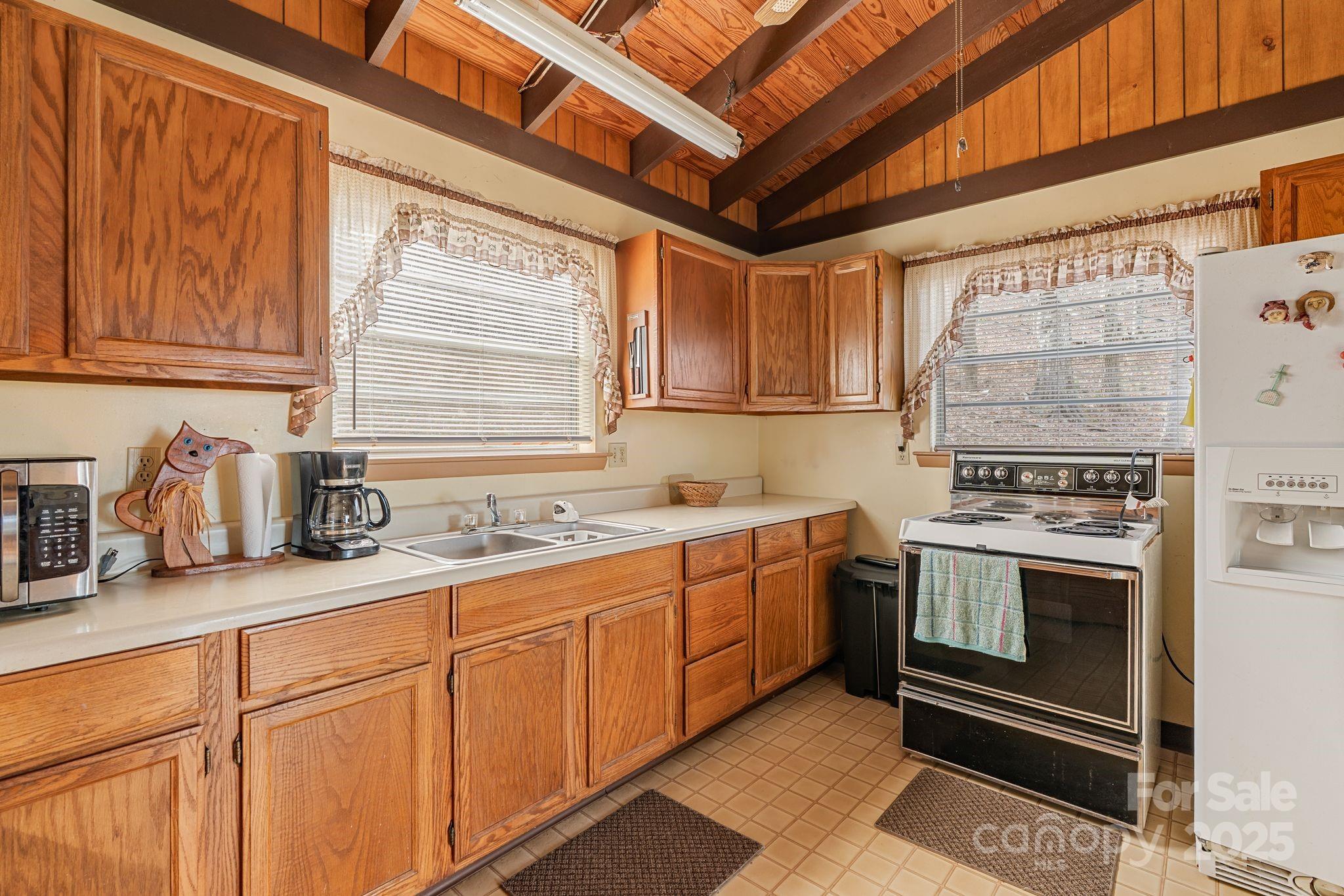 2650 Secluded Valley Road Marshall, NC 28753 - Photo 13 of 36 a kitchen with stainless steel appliances granite countertop a sink a stove and a microwave