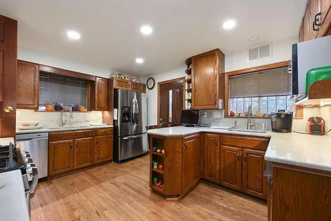a kitchen with kitchen island granite countertop wooden cabinets and stainless steel appliances