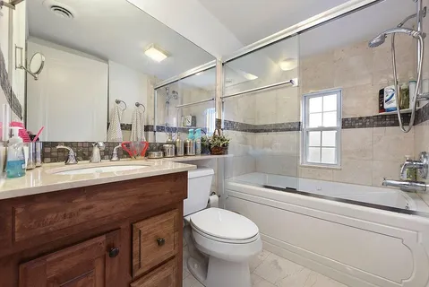 a bathroom with a sink vanity granite toilet tub and shower