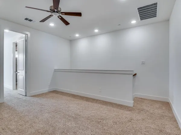 an empty room with a ceiling fan and window