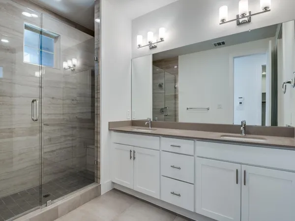 a bathroom with double sink and a mirror