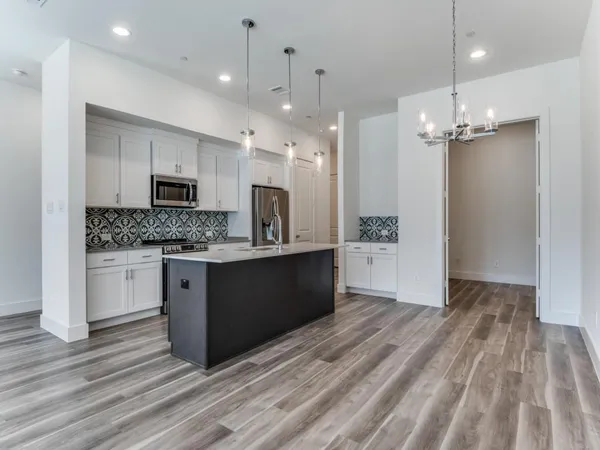 a large kitchen with a refrigerator a stove a sink and a oven