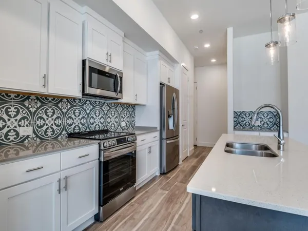 a kitchen with granite countertop a sink stove and refrigerator