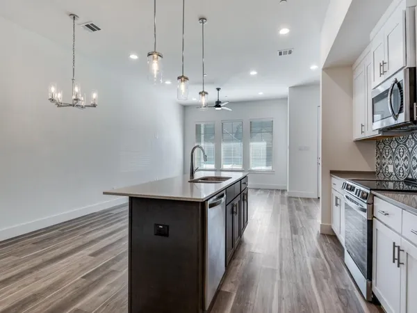 a kitchen with granite countertop a stove and a wooden floor