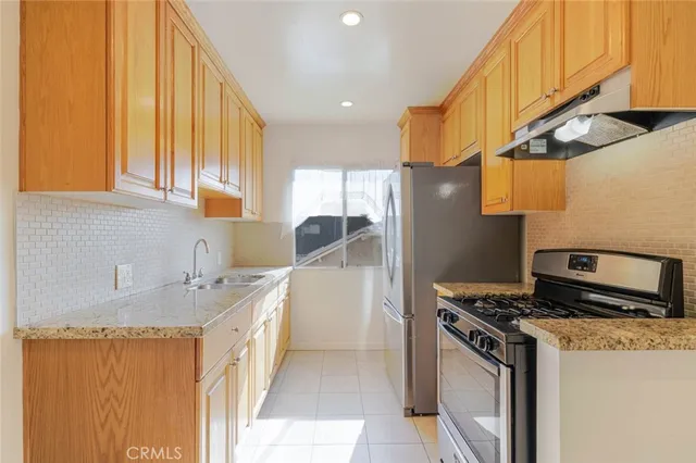 a kitchen with stainless steel appliances granite countertop a sink stove and refrigerator
