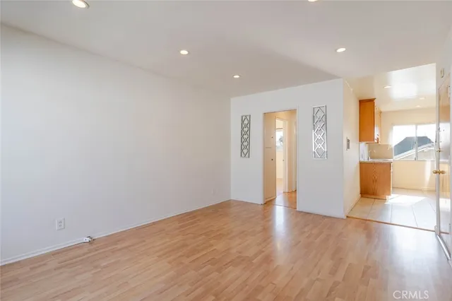 a view of a big room with wooden floor and windows