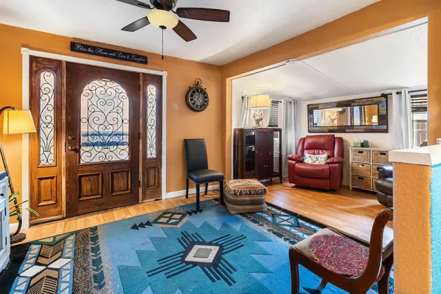 a living room with furniture kitchen view and a large window