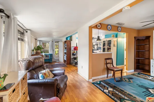 a hallway with painting on the wall and a potted plant