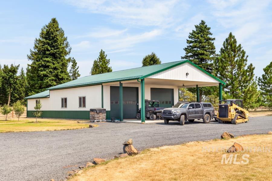 1726 Little Bear Ridge Road Troy, ID 83871 - Photo 43 of 50 Spacious shop featuring a metal roof, multiple garage doors, and a covered carport area