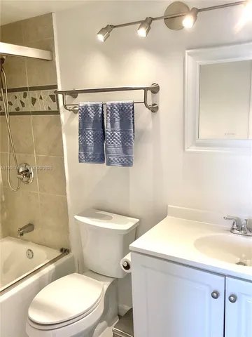 a bathroom with a toilet sink vanity shower and mirror