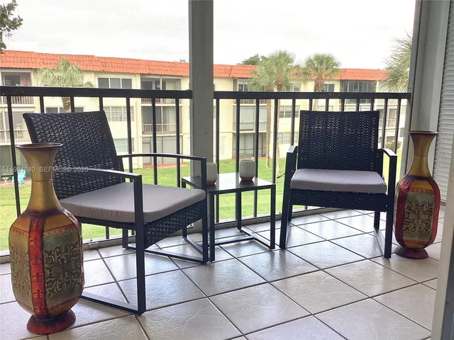 a view of a chairs and table in the balcony