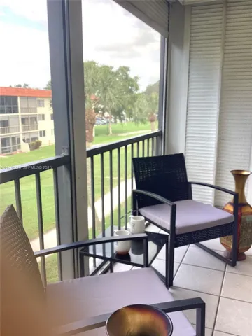 a view of a chairs and table in a balcony