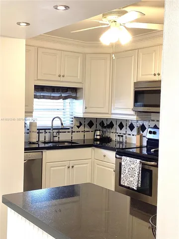 a kitchen with stainless steel appliances granite countertop a sink stove and cabinets