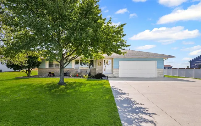 a front view of a house with a garden and trees