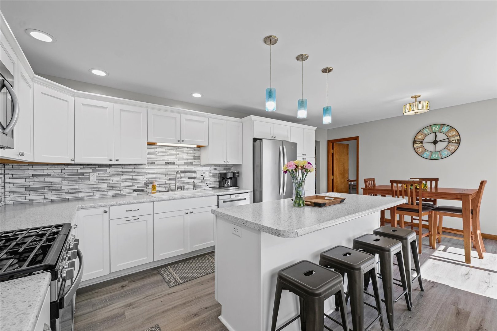 209 West Main Street Royal, IL 61871 - Photo 14 of 32 a kitchen with stainless steel appliances granite countertop a stove top oven a refrigerator a dining table and chairs with wooden floor