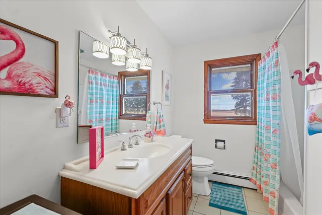 a bathroom with a sink vanity mirror and toilet