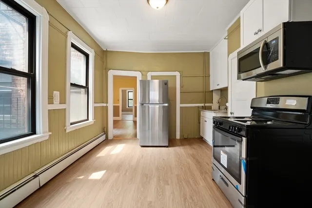 a kitchen with stainless steel appliances granite countertop a refrigerator a stove top oven a sink dishwasher and wooden floor